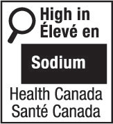 This figure shows a nutrition symbol for the principal display panel that indicates that a prepackaged product is high in sodium. This symbol is bilingual, with the English text shown first, followed by the French text. There is a white rectangular box outlined by a thin black line. At the top left of the box is a black magnifying glass. To the right of the magnifying glass is a heading composed of the words “High in” above the words “Élevé en” in black, bold, lower case letters, except that the first letter of the words “High” and “Élevé” are in upper case. Under the heading is one horizontal bar. There is a small amount of white space between both ends of the bar and the thin black line that outlines the box. The bar is black and contains the word “Sodium” in white, bold, lower case letters, except that the first letter is in upper case. Centred at the bottom of the box are the words “Health Canada” above the words “Santé Canada” in black, lower case letters, except that the first letter of each word is in upper case.